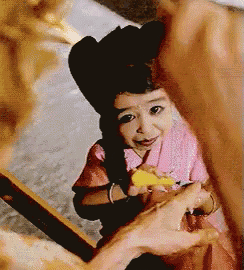 a little girl wearing a cowboy hat and a pink shirt is smiling