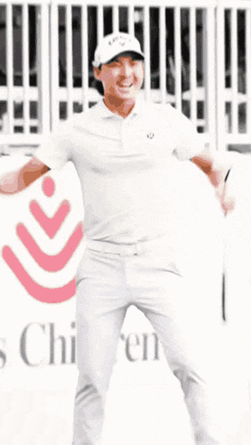 a man in a white shirt and white pants is standing in front of a sign that says children 's hospital .