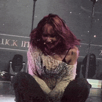 a woman with red hair is kneeling down in front of a sign that says luck