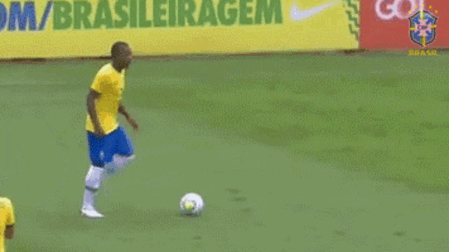 a soccer player kicks a soccer ball in front of a sign that says brasileiragem
