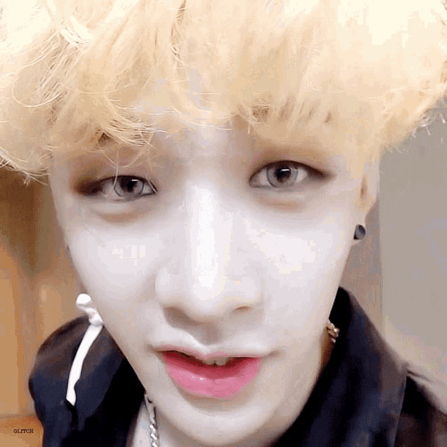 a close up of a person 's face with blonde hair and pink lipstick