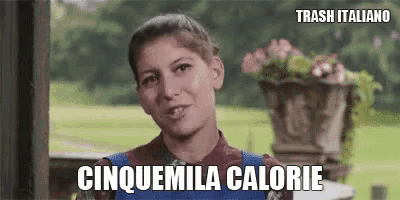 a woman is standing in front of a vase of flowers and says cinquemila calorie .