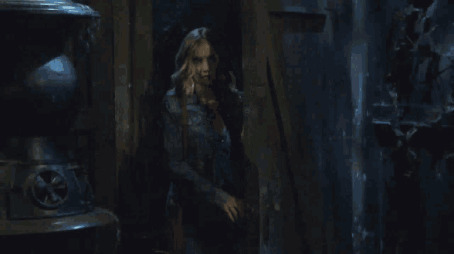 a man in a dark room holds a hammer