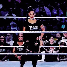 a woman in a ymaf t-shirt stands in a boxing ring