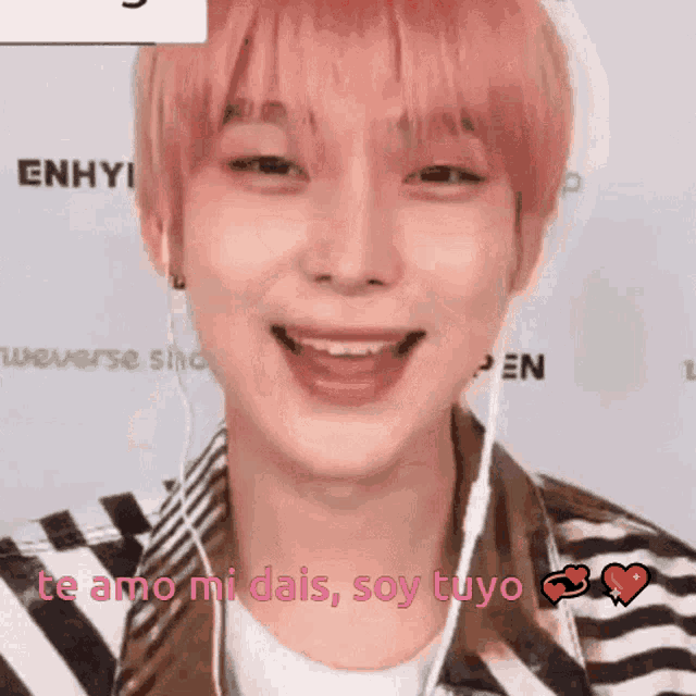 a young man with pink hair is wearing headphones and smiling while saying te amo mi dais soy tuyo