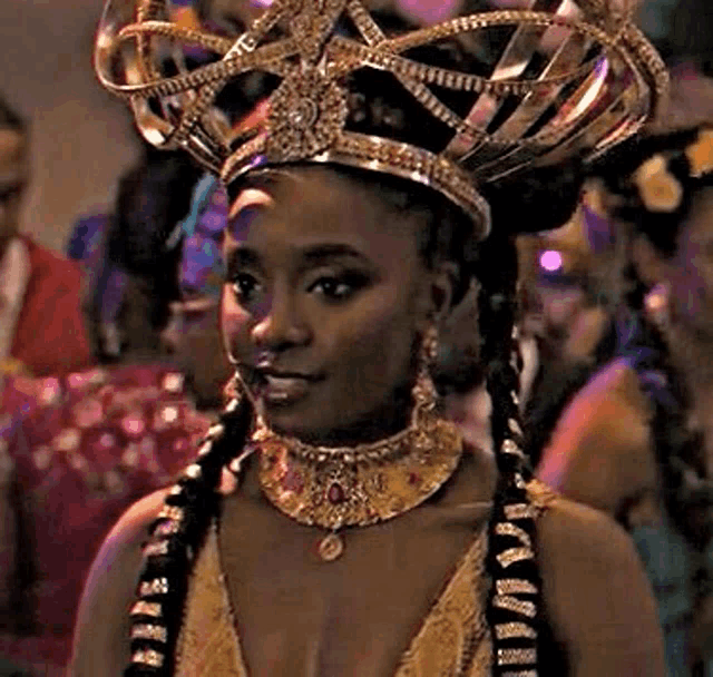 a woman is wearing a crown on her head and a necklace .