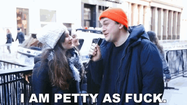 a man talking into a microphone with the words " i am petty as fuck " above him