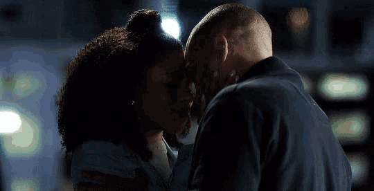 a man and a woman kissing with their foreheads touching
