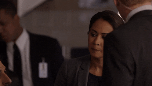 a woman in a suit has a name tag that says ' a. ' on it
