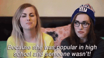 two girls are sitting on a couch and one of them is wearing a new york giants hat