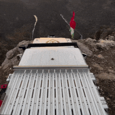 a white van is parked on top of a rocky hill