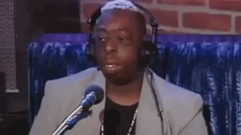 a man wearing headphones is talking into a microphone .