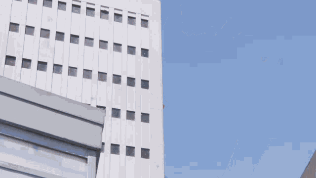 a large white building with a robot standing on the side of it