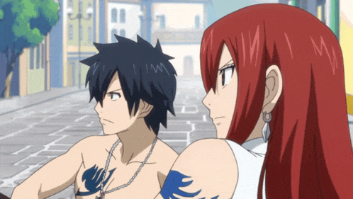 a man with a tattoo on his chest is standing next to a woman with long red hair