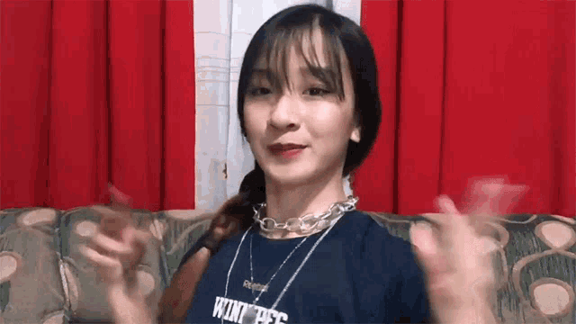 a girl is sitting on a couch wearing a shirt that says ' king ' on it