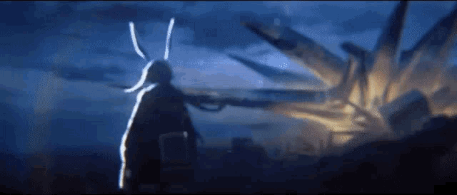 a silhouette of a person with bunny ears standing in front of a giant explosion .