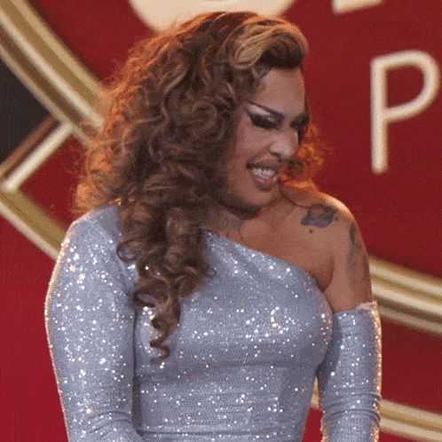 a woman in a silver dress with a tattoo on her arm