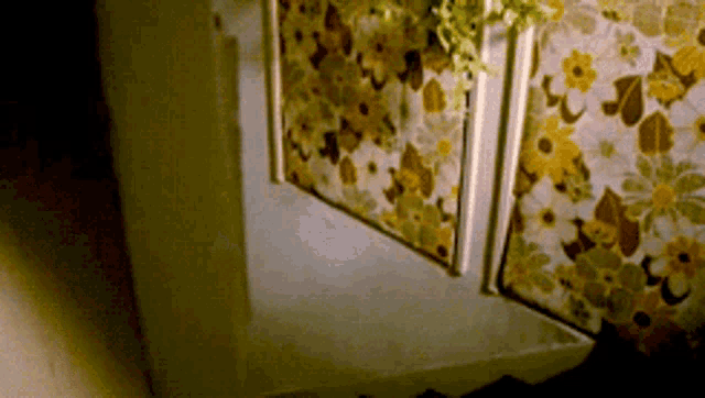 a room with a floral wallpaper and a white door