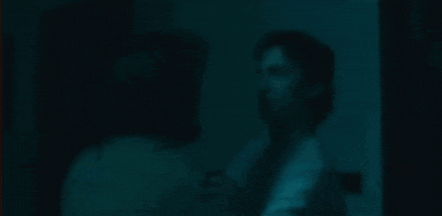 a man and woman are dancing in a dark room .