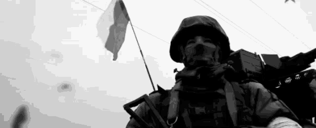 a black and white photo of a soldier with a flag
