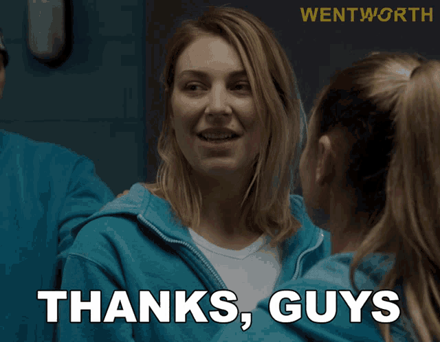 a woman in a blue hoodie says " thanks guys " in front of a group of people