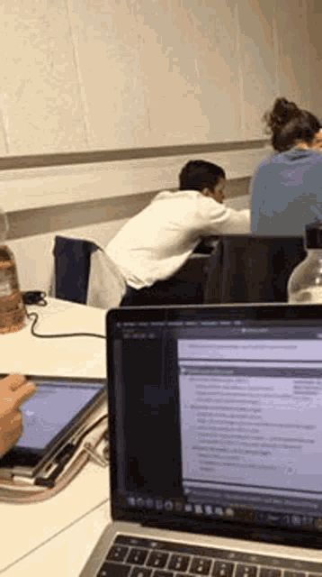 a person is sitting at a desk with a laptop and a tablet .