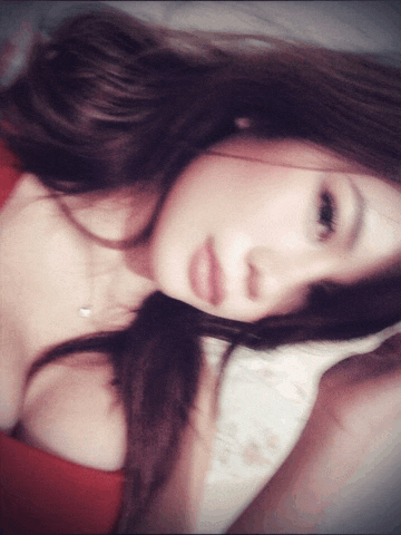 a woman in a red top is laying on a pillow