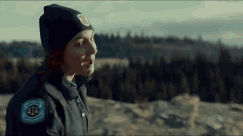 a woman wearing a beanie and a jacket with the letter jl on it