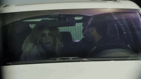 a man and a woman are sitting in a car talking to each other