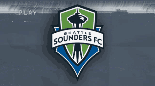 a logo for the seattle sounders fc is shown on a blurry background