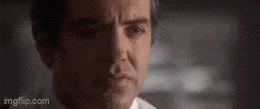 a close up of a man 's face with a slight smirk on his face .