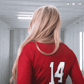 a woman wearing a red jersey with the number 14