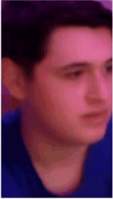 a close up of a man 's face wearing a blue shirt .