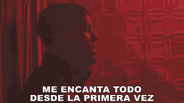 a man in a dark room with the words me encanta todo desde la primera vez above him