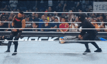 two wrestlers are in a wrestling ring with a sign that says mock on it