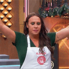a woman wearing an apron with the letter m on it is standing with her arms outstretched .