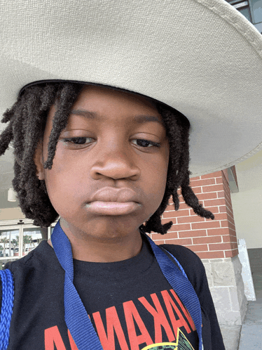 a young boy wearing a cowboy hat and a shirt that says " maxa "
