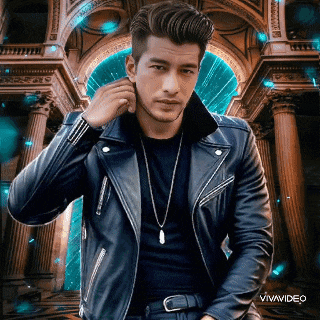 a man in a leather jacket is standing in front of a building that says vivavideo on the bottom
