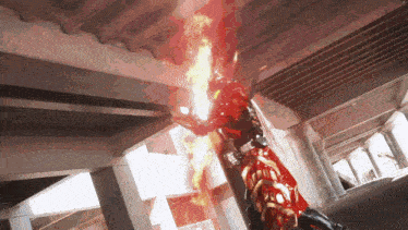 a person in a red and gold costume is holding a fireball in their hands .