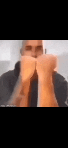 a blurry picture of a man making a fist with his hands .