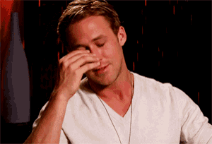 a man in a white shirt wipes his face with his hand