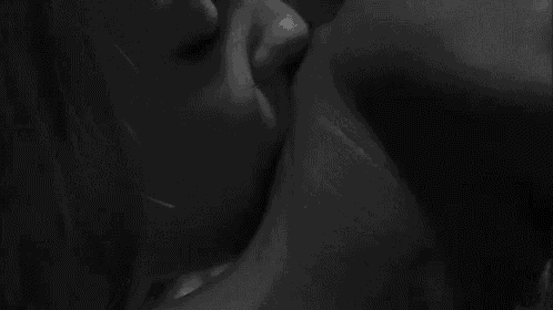 a black and white photo of a man and woman kissing each other .