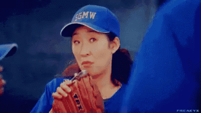 a woman is drinking from a baseball glove .