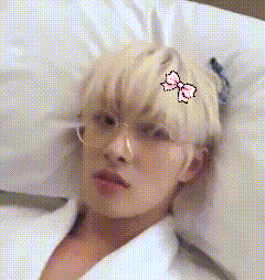 a man is laying on a bed with a bow on his head .