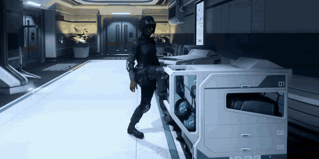 a woman in a black suit is standing next to a container with the numbers 01 and 02 on it