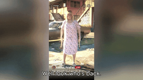 a man in a hospital gown is standing in front of a car with the words well look who 's back at the bottom