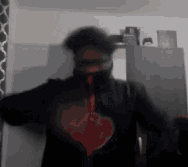 a blurry picture of a person wearing a black shirt with a heart on it