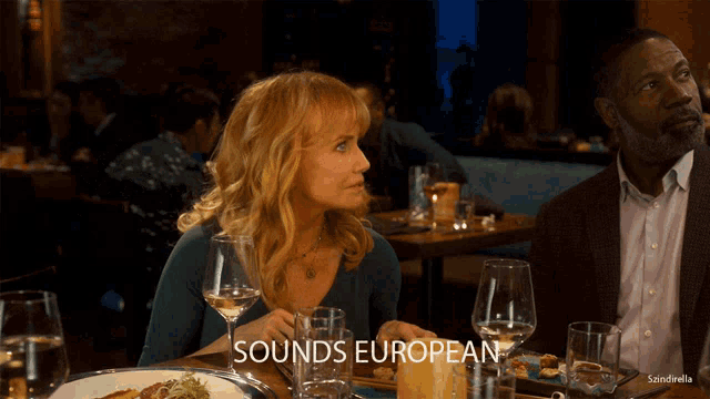 a woman sits at a table with a plate of food and a glass of wine with the words sounds european above her