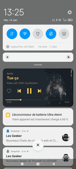 a phone screen shows a spotify app playing tue ca