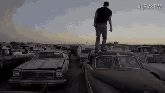 a man standing on top of a car with the letters jfd on the windshield
